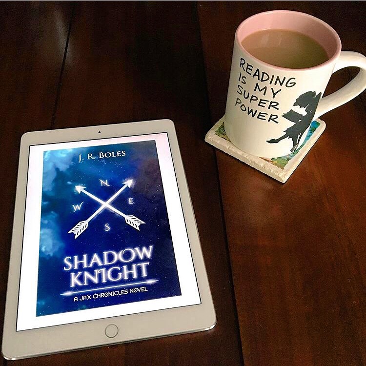 Alt Text: Image of kindle cover of SHADOW KNIGHT (compass with arrows over blue map with coffee cup showing a woman reading captioned, "Reading is my super power."